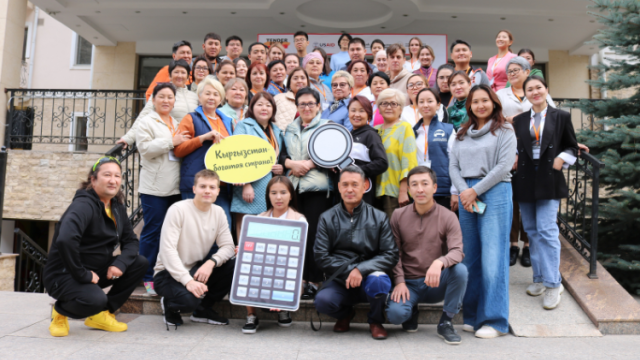 A large group of Kyrgyz people pose for a photo.